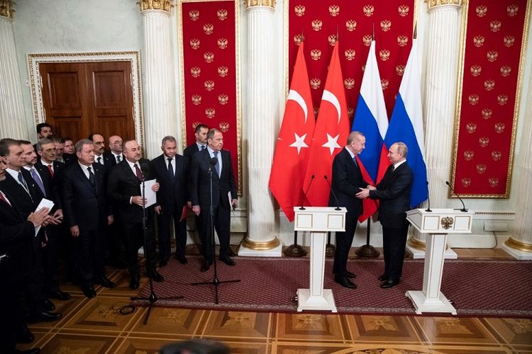 Presiden Rusia Vladimir Putin dan Presiden Turki Recep Tayyip Erdogan berjabat tangan setelah kesepakatan gencatan senjata. Kesepakatan digelar di Konferensi Pers bersama, Kremlin, Moskwa, 5 Maret 2020.