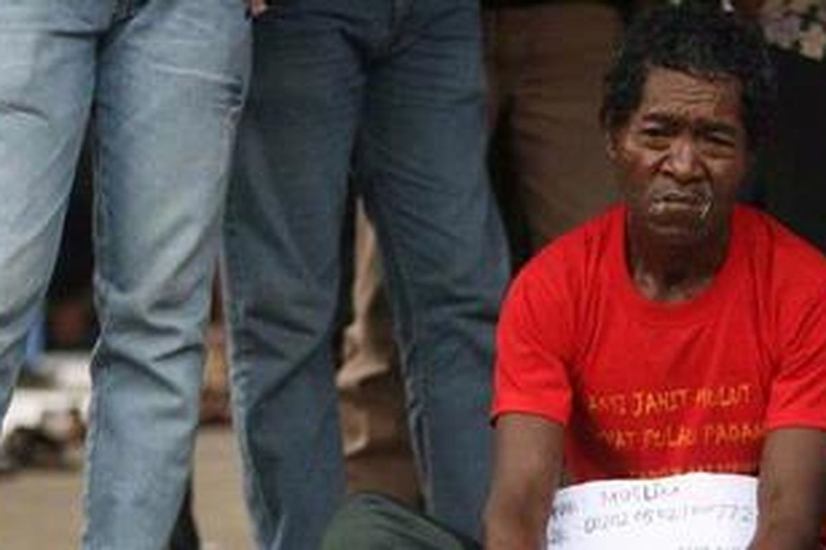 Muslim (50), bersama tujuh orang warga Pulau Padang, Kabupaten Kepulauan Meranti, Riau, menjahit mulut sebagai bentuk protes di depan Gedung DPR RI, Senayan, Jakarta, Senin (19/12/2011). Warga memprotes dan menolak kegiatan PT Riau Andalan Pulp and Paper di Pulau Padang karena mereka nilai mengancam kelangsungan hidup mereka sebab terjadi pembabatan hutan, pembuatan kanal-kanal yang dapat meningkatkan abrasi sehingga pulau terluar Indonesia itu terancam tenggelam.