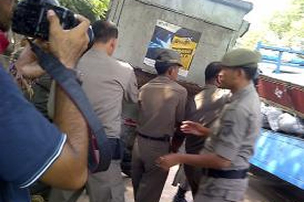 Petugas Satpol PP saat melakukan penertiban pedagang kaki lima di Pasar Gembrong, Jakarta Timur, Kamis (12/9/2013). Pedagang kaki lima yang nekat berjualan akan dikenakan tindak pidana ringan.