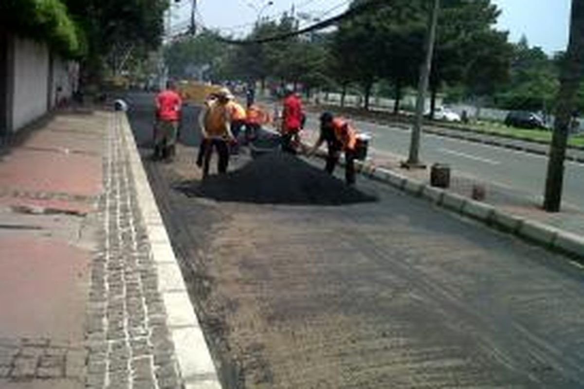 Puluhan petugas Suku Dinas Pekerjaan Umum Jalan Jakarta Pusat sedang mengaspal Jalan Prapatan, Gambir, Jakarta Pusat, setelah pos pemeriksaan dan pangkalan taksi di depan Hotel Aryaduta, dibongkar pada Senin (2/12/2013).