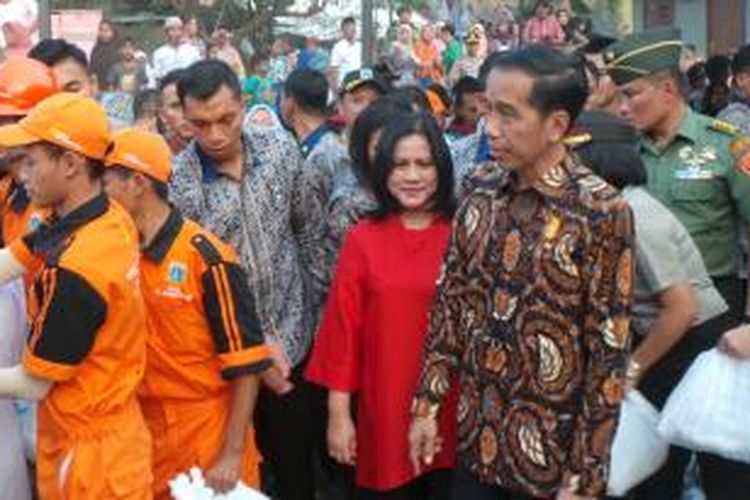 Presiden Joko Widodo bersama Ibu Negara Iriana Joko Widodo saat membagikan paket sembako di Lapangan Bedeng, Pisangan Baru Tengah, Pisangan Baru, Kecamatan Matraman, Kota Jakarta Timur, Selasa (8/9/2015).