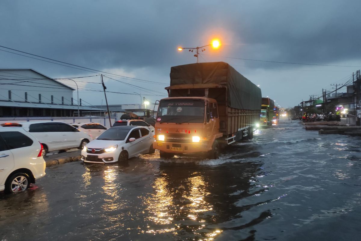 Sejumlah kendaraan melintas di Pantura Kecamatan Sayung, Kabupaten Demak, Jawa Tengah dalam kondisi banjir rob, Minggu (6/4/2025) malam.