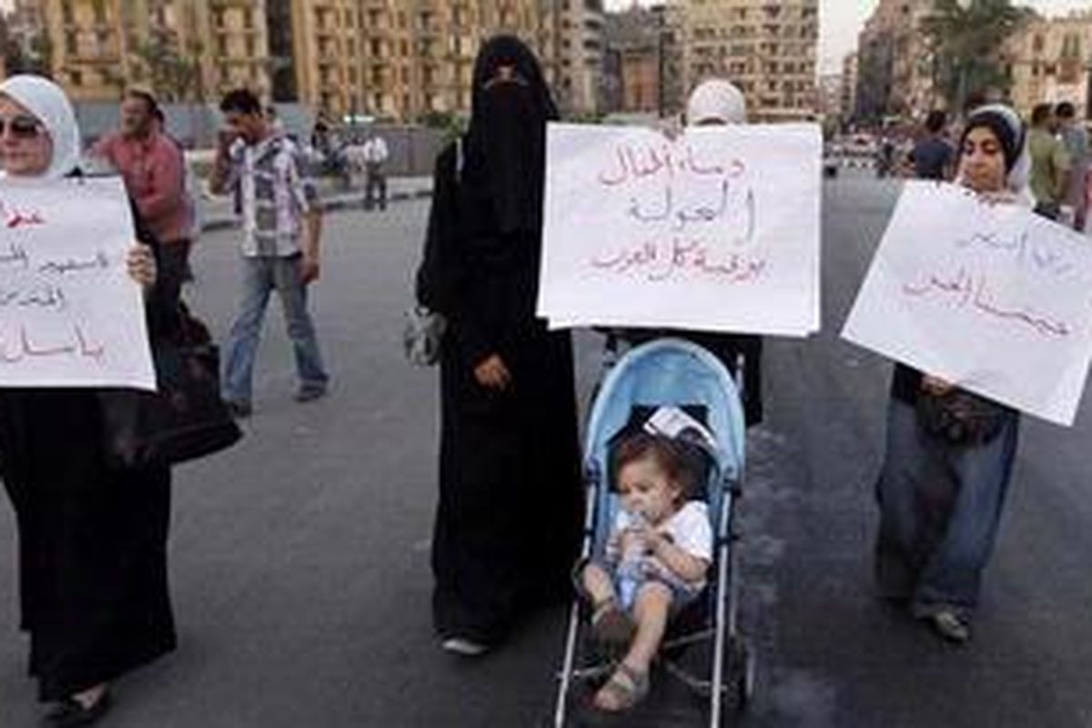 Para perempuan Suriah yang tinggal di Mesir membawa poster bertuliskan "Semua Arab bertanggung jawab atas tumpahnya darah anak-anak di Houla" dan "Semoga Tentara Pembebasan (Suriah) menang", dalam sebuah unjuk rasa di Lapangan Tahrir, Kairo, Kamis (31/5/2012). Mereka menentang pembantaian yang menewaskan lebih dari 100 orang di Houla, Suriah, pekan lalu. 