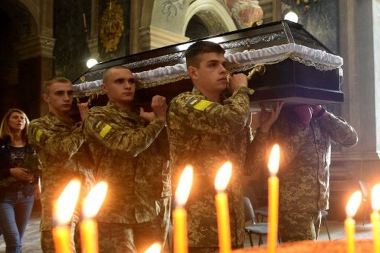 Tentara Ukraina membawa peti mati Andriy Vertiev dan Serhiy Evtushenko, prajurit Ukraina, yang terbunuh selama invasi Rusia ke Ukraina, selama pemakaman mereka di Gereja Saints Peter and Paul Garrison, di kota Lviv pada 25 Mei 2022. 