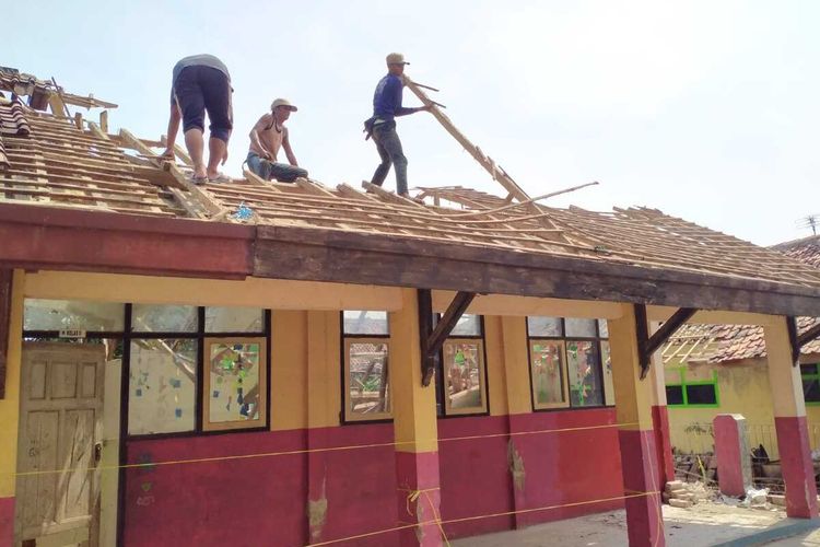 Sejumlah pekerja sedang memperbaiki atap gedung SDN Bayur Kidul 1 yang ambruk.