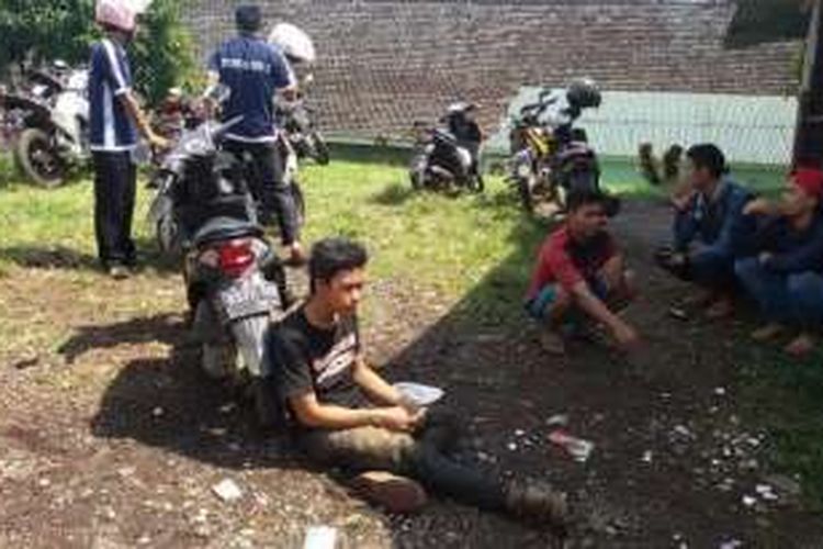 Agus (20), warga Kampung Cimacan, Desa Haurpanggung, Kecamatan Tarogong Kidul, Kabupaten Garut yang terus mencari keberadaan paman dan bibinya, terduduk lemas di lokasi identifikasi jenazah Rumah Sakit Guntur, Rabu (21/9/2016). 