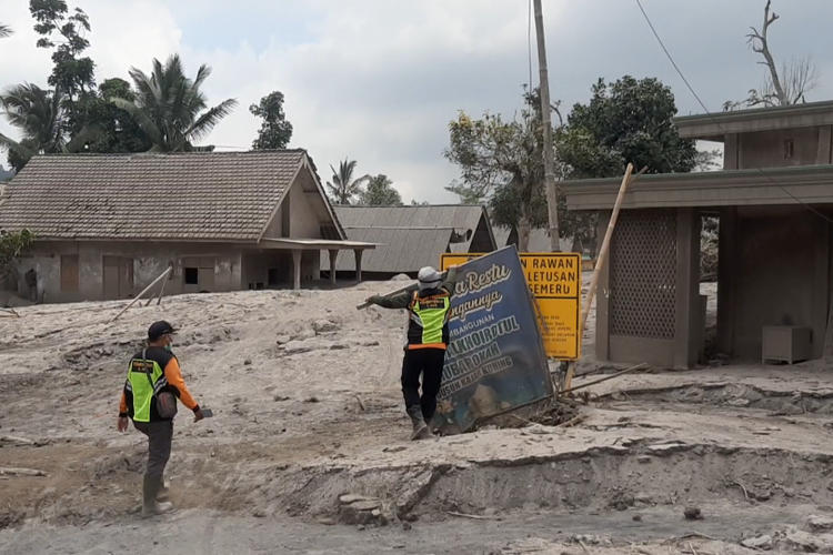 Petugas membersihkan kawasan yang tertimbun material APG Semeru di Dusun Kamar Kajang, foto diambil 5 Desember 2022.