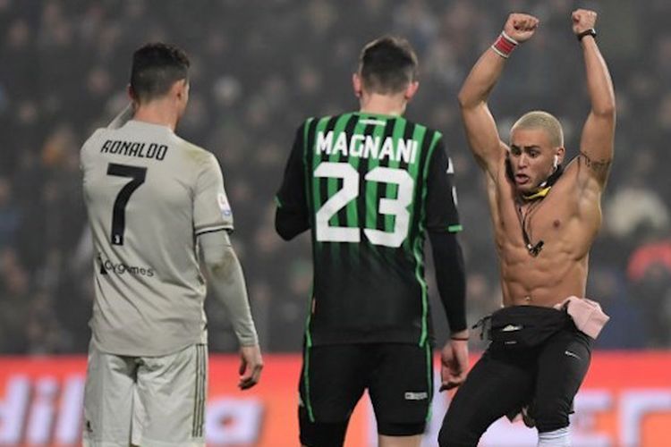 Cristiano Ronaldo dan Giangiacomo Magnani hanya bisa menyaksikan seorang penonton menerobos masuk lapangan Stadion Mapei saat laga Sassuolo vs Juventus dalam lanjutan Serie A Liga Italia, 10 Februari 2019. 