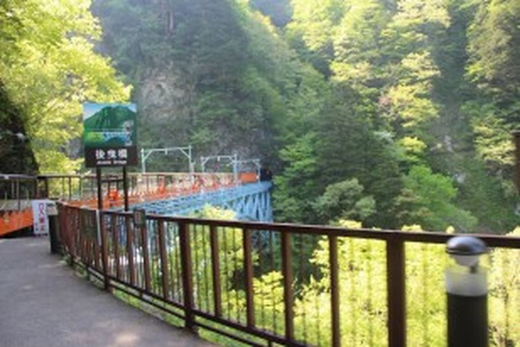 Kereta api Kurobe Gorge melintasi Jembatan Atobiki dan memasuki satu dari 41 terowongan yang dilalui dalam perjalanan menjelajah Kurobe Gorge.