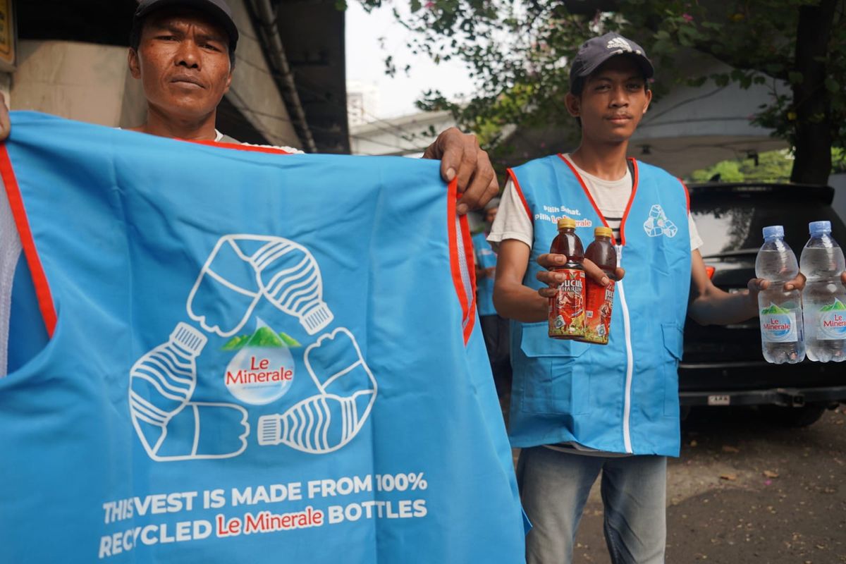 Le Minerale bagikan rompi gratis hasil daur ulang kepada pedagang asongan.