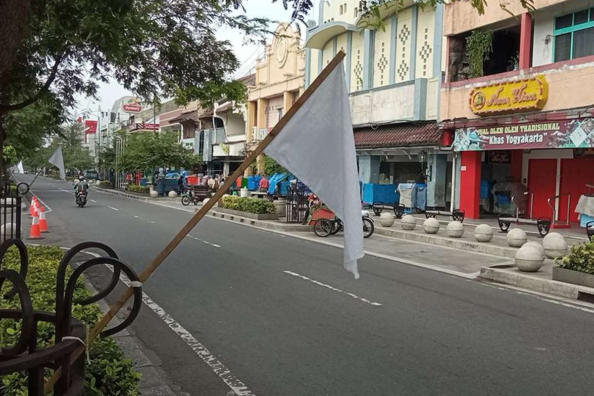 Bendera putih dipasang di sepanjang Jalan Malioboro, DI Yogyakarta, sebagai tanda pedagang kaki lima (PKL) menyerah hadapi pandemi, Jumat (30/7/2021). Para pedagang memasang bendera putih di sepanjang jalan masuk Malioboro hingga di depan kantor Gubernur DI Yogyakarta sebagai simbol ketidakberdayaan dan kesedihan atas kondisi pandemi Covid-19 yang tak kunjung selesai.