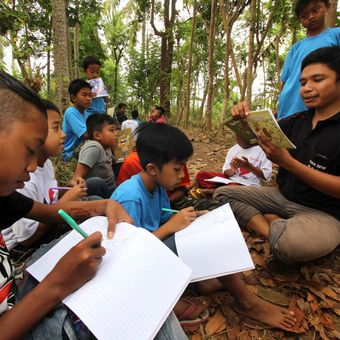 Relawan mendampingi anak-anak menulis proses mencapai cita-citanya di sekolah alam Kampung Batara di Papring, Banyuwangi, Jawa Timur, Minggu (24/9). Kegiatan edukasi tersebut bertujuan untuk memperkuat literasi pada anak-anak sekolah alam yang terletak di pinggir hutan produksi perhutani. ANTARA FOTO/Budi Candra Setya/foc/17.