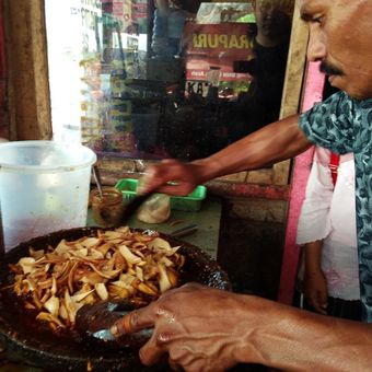 Pemilik kedai rujak sedang mengaduk batok kelapa sebagai bahan baku rujak batok kelapa (rujak U Groh) dengan bumbu rujak dan siap disajikan kepada pengunjung. Ini rujak khas yang disajikan di kawasan Indrapuri Kabupaten Aceh Besar