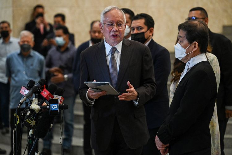 Mantan Perdana Menteri Malaysia Najib Razak (tengah) berbicara dengan pengacaranya, Hisyam Teh Poh Teik (kanan) dalam konferensi pers di Pengadilan Federal, Putrajaya, 18 Agustus 2022. Najib Razak sedang menjalani persidangan atas kasus korupsi 1MDB (1Malaysia Development Berhad).