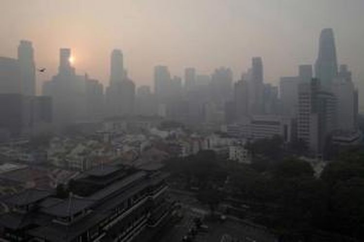 Matahari pagi berupaya menerobos kabut asap yang menyelimuti Singapore Central Business District (CBD), 20 Juni 2013. Kabut asap berasal dari kebakaran hutan di Sumatera, Indonesia.