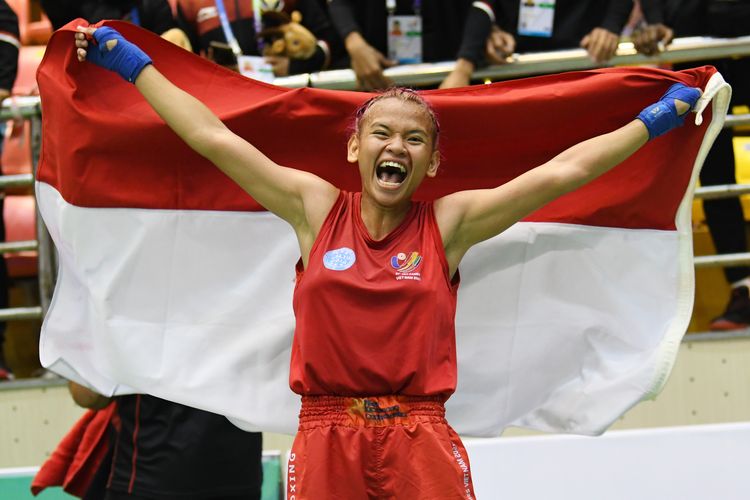 Atlet Indonesia Amanda La Loupatty melakukan selebrasi sambil membawa bendera Merah Putih usai mengalahkan lawannya atlet asal Filipina Decena Claudine Veloso dalam pertandingan babak final kelas -52 kilogram putri nomor low kick Kickboxing SEA Games 2021 Vietnam di Bac Ninh Gymnasium, Bac Ninh, Vietnam, Jumat (13/5/2022). Amanda berhasil meraih medali emas setelah menang atas lawannya dengan skor 3-0. ANTARA FOTO/Aditya Pradana Putra/YU