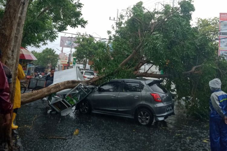 Sebuah mobil tertimpa pohon yang roboh akibat terjangan angin dan hujan deras di Kota Kediri, Jawa Timur, Senin (9/12/2019).