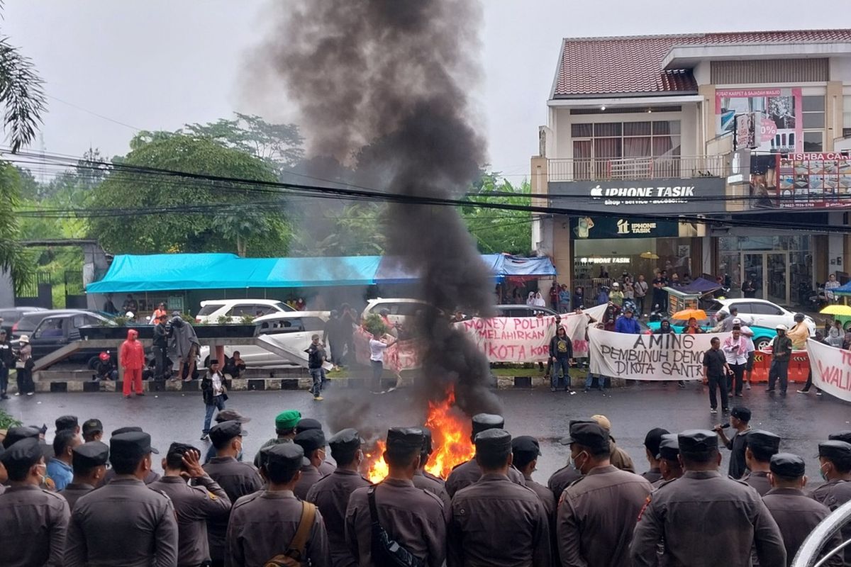 Sekelompok masyarakat berunjukrasa sambil membakar ban dan memblokir jalan menolak rapat pleno penetapan pemenang pilkada oleh KPU Kota Tasikmalaya di depan Hotel Grand Metro Tasikmalaya, Jawa Barat, Senin (2/12/2024).