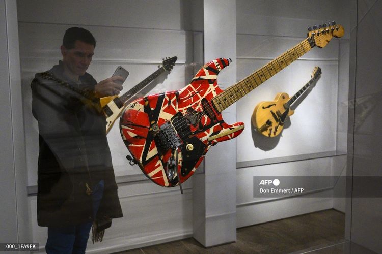 Seorang reporter memotret Frankenstein, gitar yang digunakan Eddie Van Halen, pada pameran Play It Loud: Instruments of Rock and Roll di Metropolitan Museum of Art di New York pada 1 April 2019.