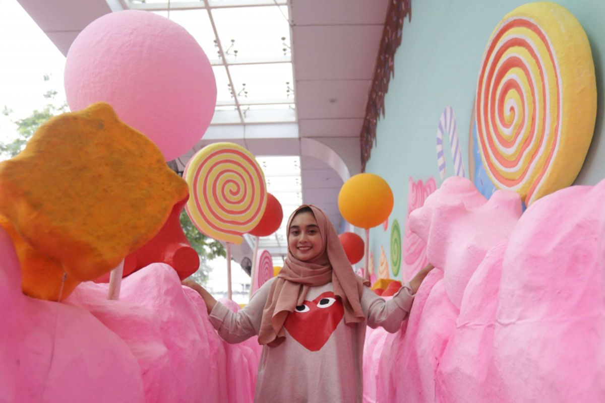 Seorang pengunjung berpose di salah satu spot wahana sweet treats di Scientia Square Park (SQP), Serpong, Tangerang, Banten, Selasa (8/1/2019). Dengan harga tiket Rp 35.000 pengunjung bebas berfoto di berbagai spot dengan latar replika makanan manis yang didominasi warna pastel, event ini akan berlangsung hingga April 2019 mendatang.
