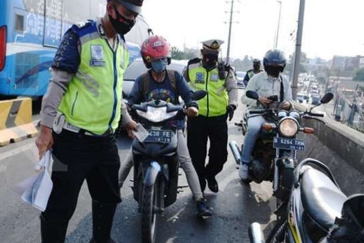 Petugas kepolisian menindak pengendara sepeda motor yang melintas fly over Pesing, Daan Mogot, Jakarta Selatan 