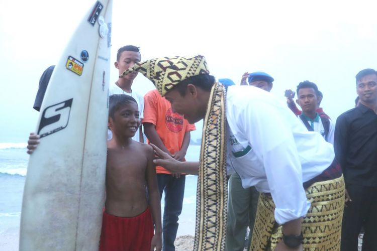 Menteri Pemuda dan Olahraga Imam Nahrawi saat menemui salah satu peselancar cilik di Pantai Labuham Jukung, Krui, Kabupaten Pesisir Barat, Lampung, Jumat (13/4/2018).