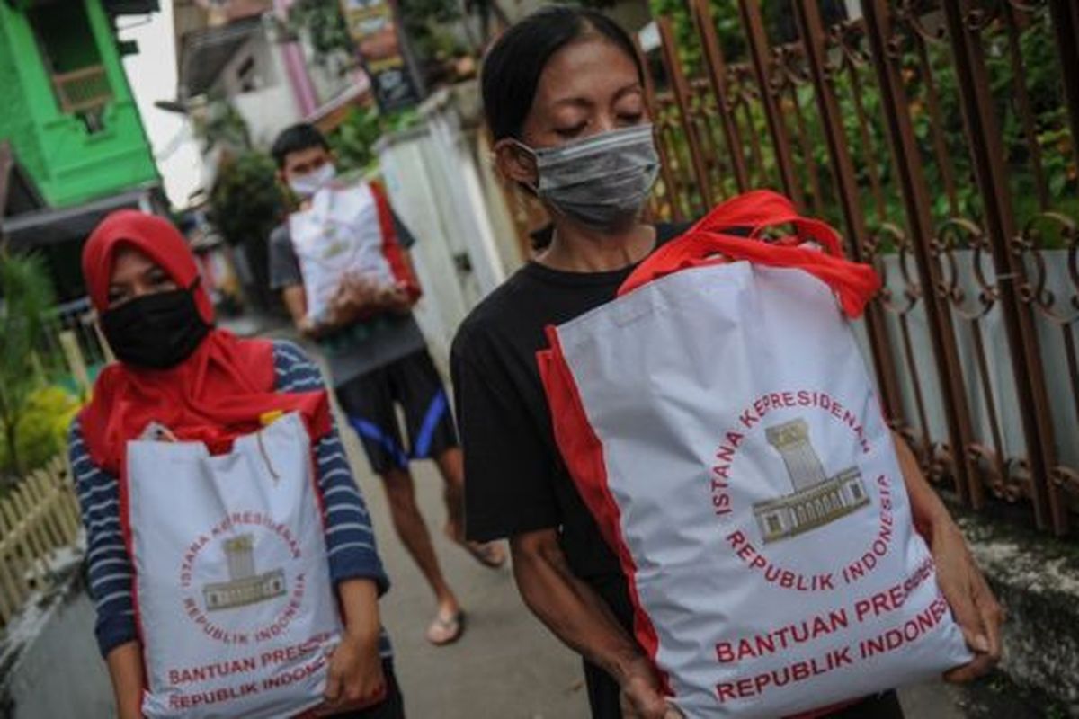 Warga membawa bingkisan berupa bantuan sosial dari Presiden di Cibeunying Kidul, Bandung, Jawa Barat, Senin (04/05). 
