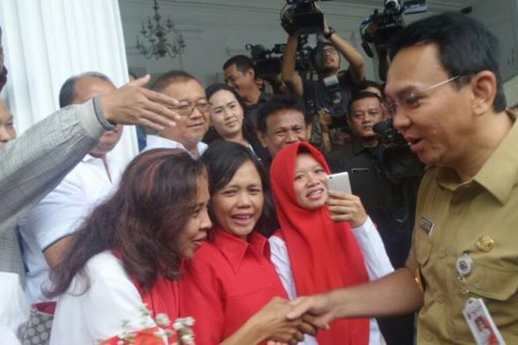 Gubernur DKI Jakarta Basuki Tjahaja Purnama menerima bunga dari anggota organisasi Solidaritas Merah Putih di Balai Kota DKI Jakarta, Selasa (14/2/2017). 