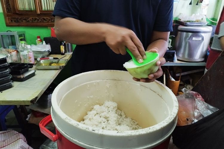 Pemilik Warung Nasi Raos, Reza (30), menyiapkan nasi untuk pelanggannya, Rabu (15/2/2023). (KOMPAS.com/XENA OLIVIA)