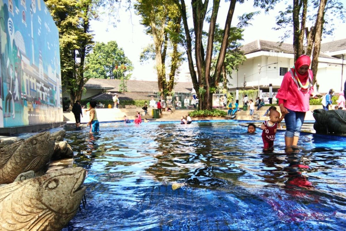 Wisatawan sedang berjalan-jalan di salah satu taman yang berlokasi di Kota Bandung.