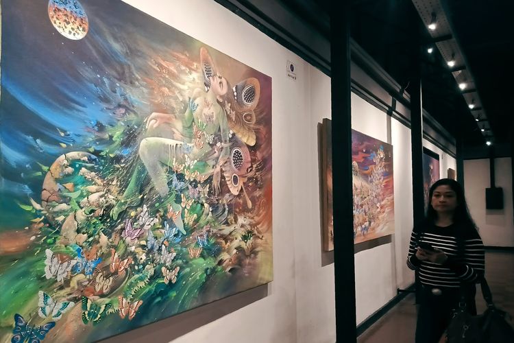 Seorang pengunjung menyaksikan lukiasan hasil karya pameran tunggal pelukis asal Surabaya Buggy Budiyanto dalam rangka memperingati Hari Kebangkitan Nasional di Galeri Dewan Kesenian Surabaya, Selasa (20/5/2025) malam.