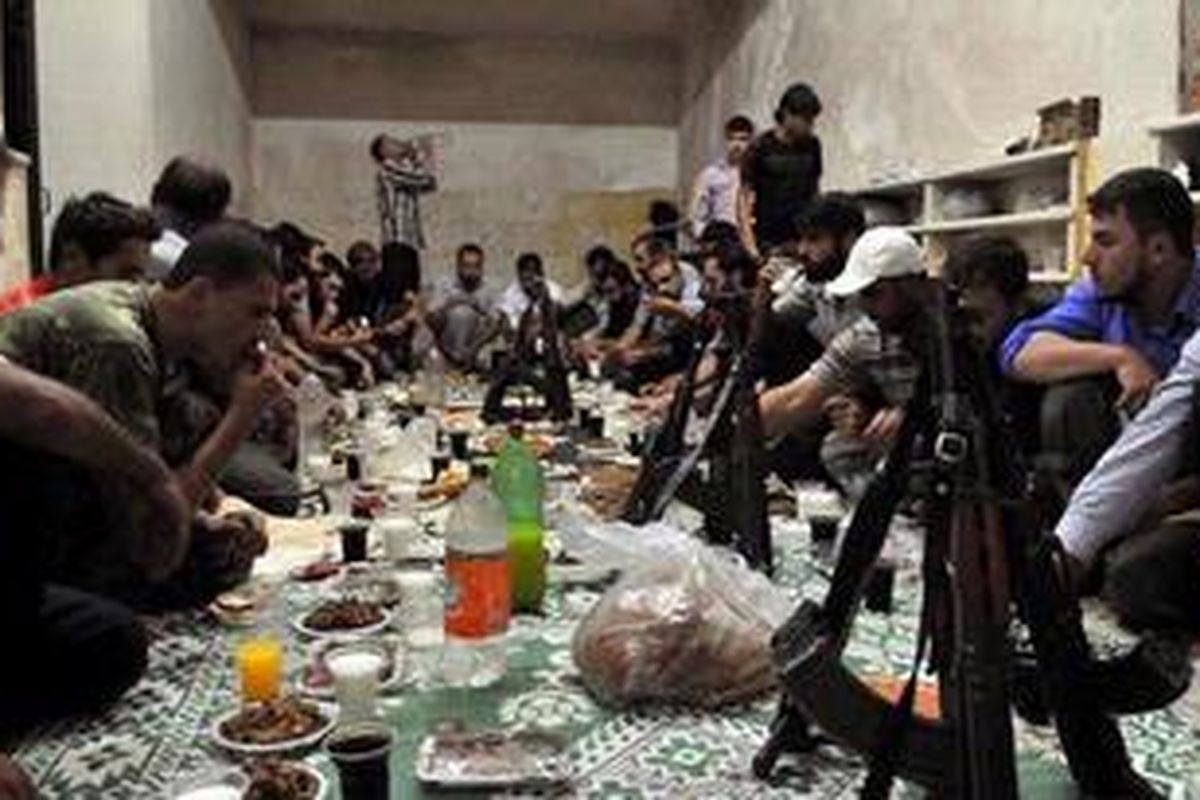 Para pemberontak Suriah berbuka puasa bersama di Aleppo, Selasa (24/7/2012). Dalam sepekan terakhir, kota terpadat di Suriah itu menjadi medan pertempuran paling sengit antara pasukan pemerintah dengan pemberontak.   