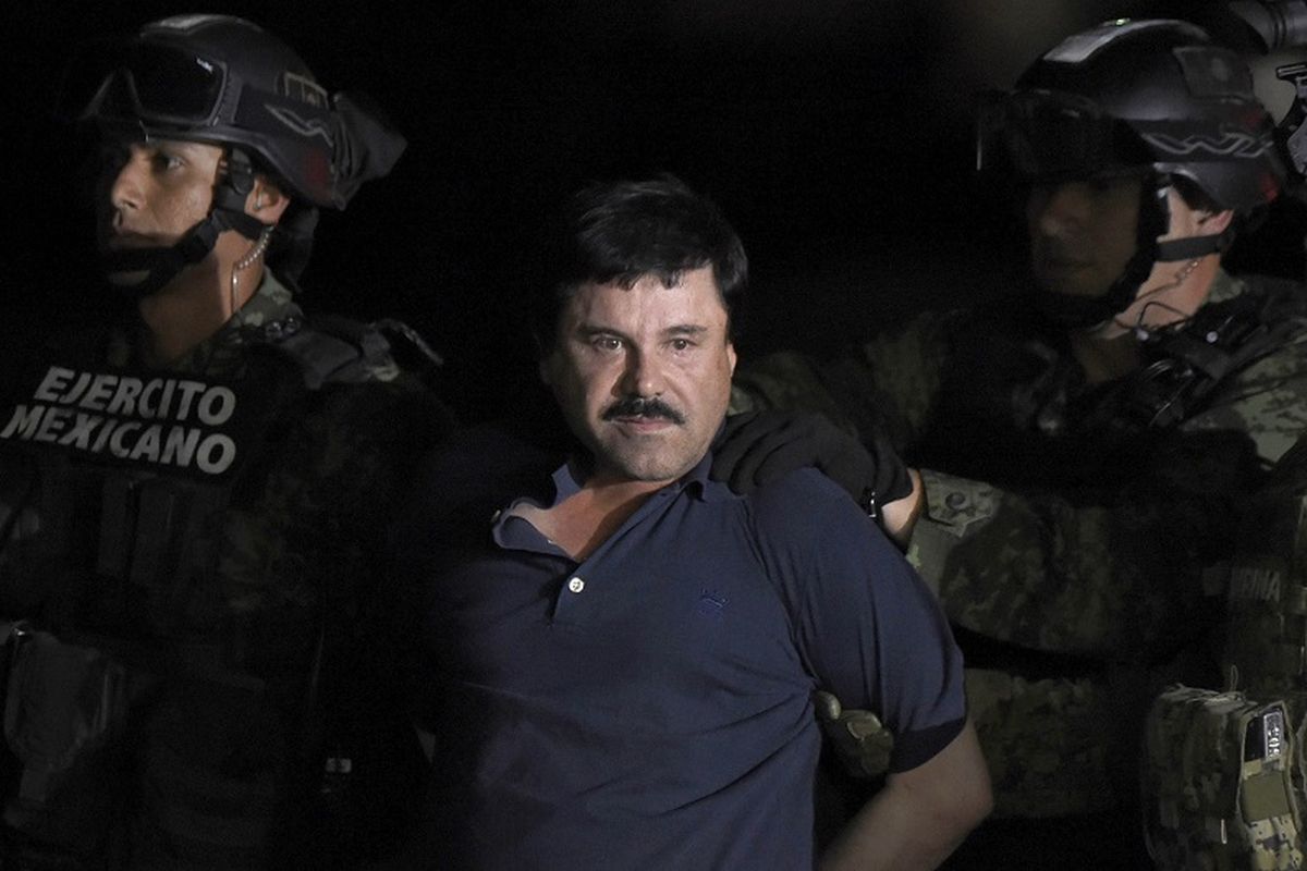 Dalam foto yang diambil pada 8 Januari 2016 ini terlihat gembong narkoba Joaquin El Chapo Guzman digiring menuju sebuah helikopter di sebuah bandara di Mexico City setelah militer menangkapnya di Los Mochis, negara bagian Sinaloa setelah sempat kabur dari penjara.