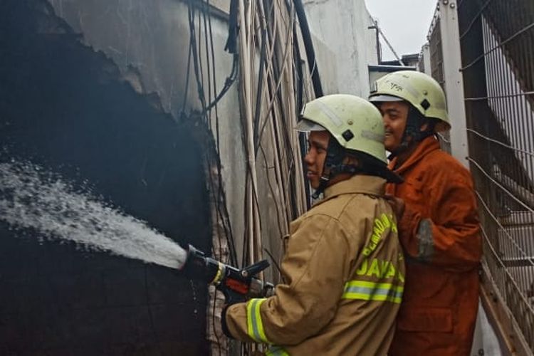 Saepul (29) sedang memadamkan api di lokasi kebakaran di salah satu kelurahan di Tambora, Jakarta Barat. (Dok : Saepul Rohman)