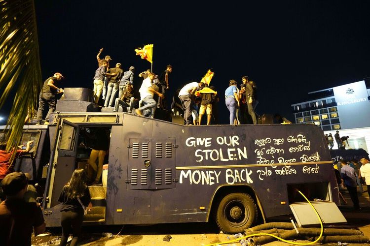 Para pengunjuk rasa berdiri di atas truk water canon polisi yang dirusak dan meneriakkan slogan-slogan di pintu masuk kediaman resmi presiden di Kolombo, Sri Lanka, Sabtu, 9 Juli 2022.