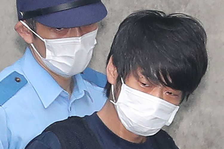 Tetsuya Yamagami (kanan) yang merupakan penembak Shinzo Abe dikawal polisi saat keluar dari kantor polisi Nara Nishi untuk menuju pengadilan di kota Nara, Minggu (10/7/2022). Shinzo Abe mantan PM Jepang ditembak dan tewas saat berpidato dalam kampanye menjelang pemilihan di Nara, Jumat (8/7/2022).