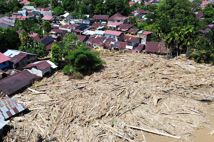 KAYU GELONDONGAN: Foto udara tumpukan gelondongan kayu di permukiman di Tabiang Bandang Gadang, Nanggalo, Padang, Sumatera Barat, Selasa (9/12/2025). Gelondongan kayu yang terbawa banjir bandang sejak dua pekan lalu masih tersangkut di wilayah itu.  