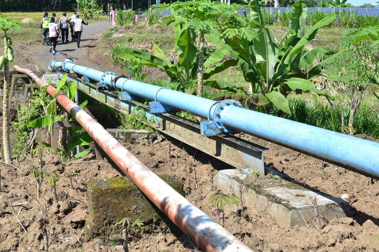 Saluran pipa untuk menyalurkan air dari Kali Tajum ke sawah di Desa Kaliurip, Kecamatan Purwojati, Kabupaten Banyumas, Rabu (29/6/2022). Air dari Kali Tajum dialirkan ke atas melalui pipa ini dengan pompa air bertenaga pembangkit listrik tenaga surya (PLTS).