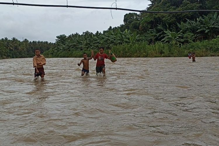 Foto: Para siswa Sekolah Dasar Inpres (SDI) Blawuk, Kecamatan Talibura, Kabupaten Sikka, NTT, sedang menyebrangi sungai agar bisa ke sekolah.