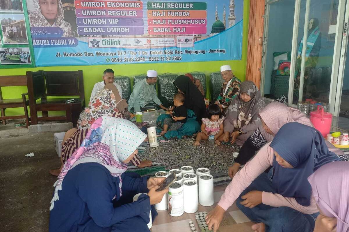 Petugas Travel Haji dan Umrah Assalaam Berkah Abadi (Asabi) Mojoagung, Jombang, Jawa Timur, menghitung jumlah uang koin yang digunakan salah calon jemaah untuk membayar biaya umrah, Kamis (3/10/2024).