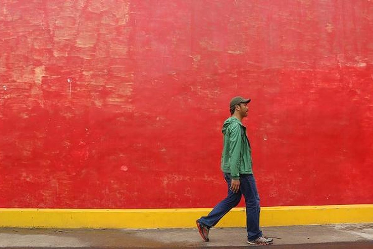 Wisatawan melewati tembok rumah merah atau juga dikenal dengan sebutan Tiongkok Kecil Heritage di Desa Karangturi, Kecamatan Lasem, Kabupaten Rembang, Jawa Tengah, Jumat (10/2/2017). Tiongkok Kecil Heritage adalah salah satu bangunan bergaya Cina Hindia di Desa Karangturi yang telah direnovasi.