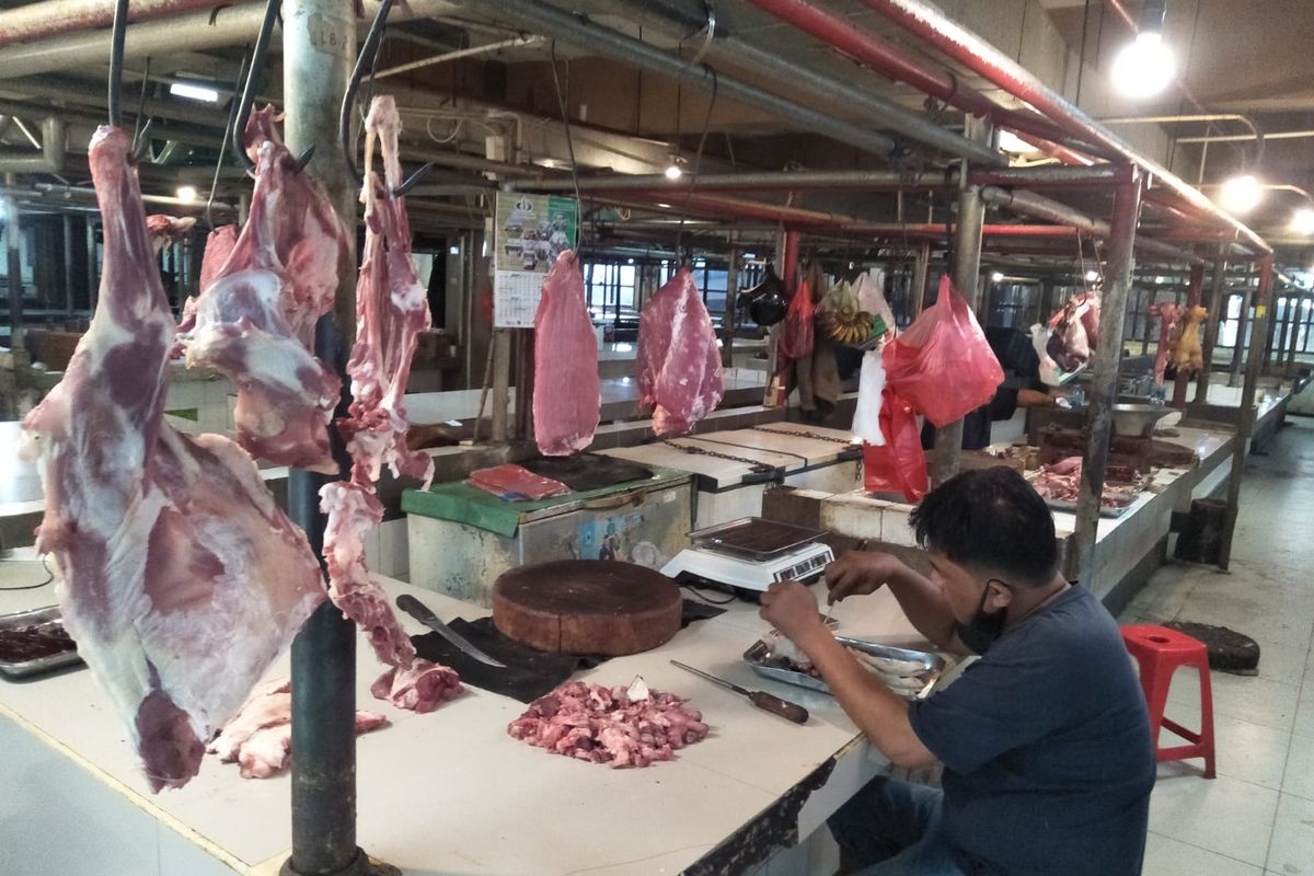 Anton, salah satu pedagang daging sapi di Pasar Cisalak, Cimanggis, Depok, tengah menguliti bagian daging untuk dijual.