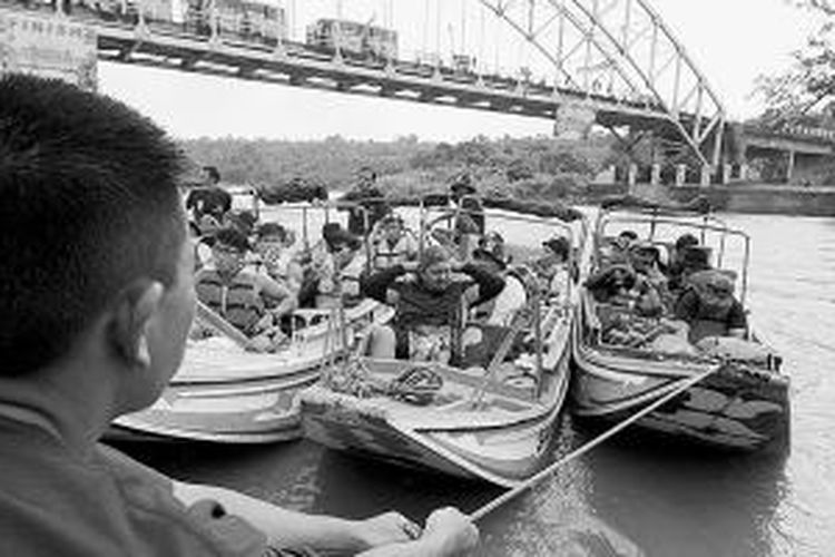 Andri (35), pengemudi perahu kayu, mengantar peserta lomba Musi Triboatton menyusuri Sungai Musi dari Kecamatan Tebing Tinggi, Kabupaten Empat Lawang, sejauh 140 kilometer, Rabu (26/11/2014). 