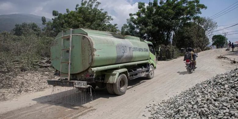 Salah satu mobil tangki milik perusahaan tambang bebatuan menyiram jalan yang dipenuhi debu menggunakan air di lingkar tambang Kelurahan Buluri, Palu, Sulawesi Tengah, 4 Juni 2024.