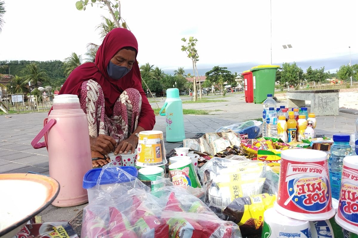 Riam pedagang asongan di Kuta Mandalika saat menjajakan dagangannya.