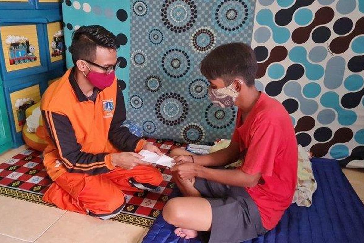 Petugas PPSU Duri Pulo, Angga memberikan donasi kepada Mulyadi, ayah Kenzi, untuk membelikan susu khusus bayi penderita epilepsi intraktabel pada Senin (12/7/2021).