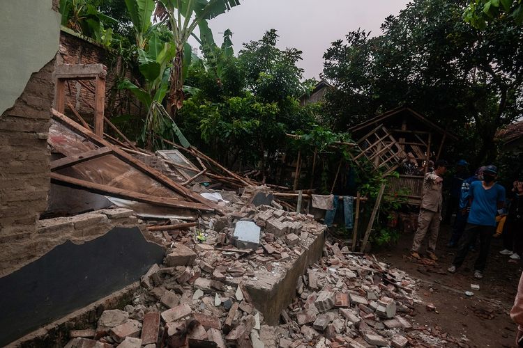 Warga melihat kondisi rumah yang rusak akibat gempa di Kadu Agung Timur, Lebak, Banten, Jumat (14/1/2022). Gempa berkekuatan 6,7 SR tersebut mengakibatkan sejumlah rumah rusak. ANTARA FOTO/Muhammad Bagus Khoirunas/rwa.