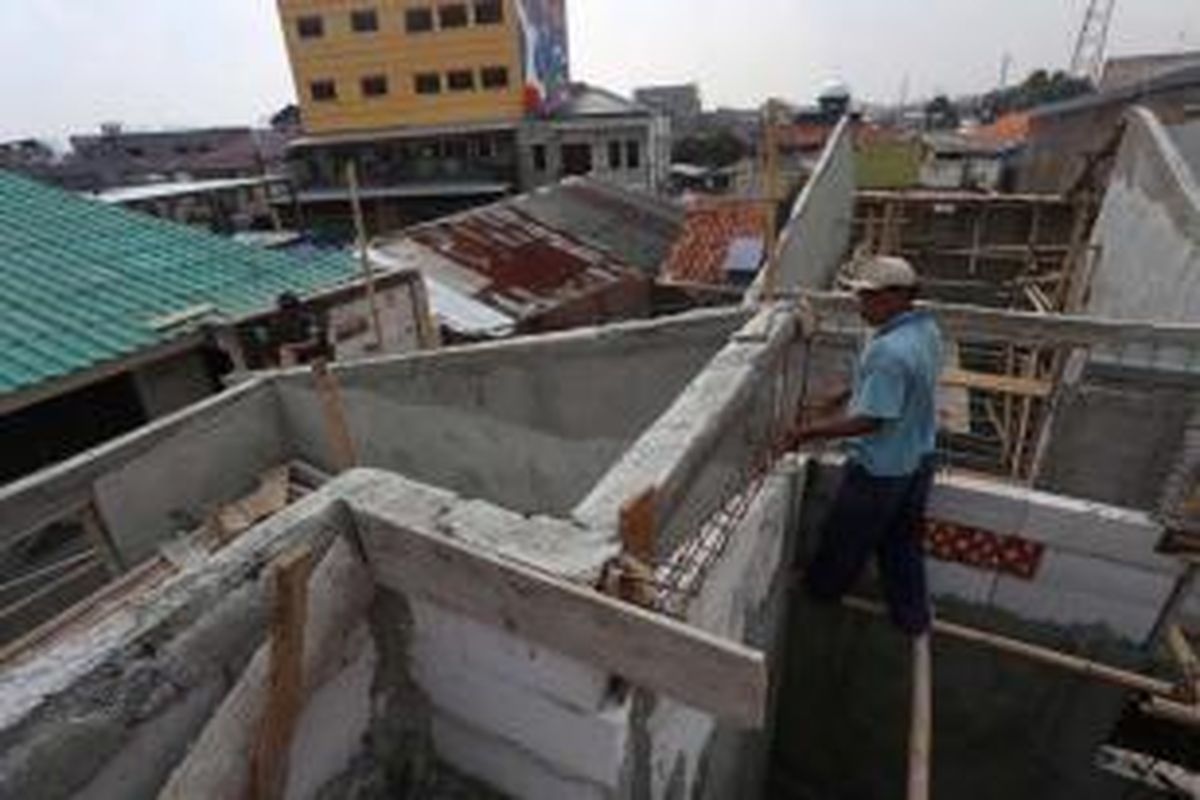 Pekerja menyelesaikan pembangunan Kampung Deret di Jalan Tanah Tinggi I RT 14 RW 01, Johar Baru, Jakarta Pusat, Selasa (2/7/2013). Kampung deret digagas Gubernur DKI Jakarta Joko Widodo.