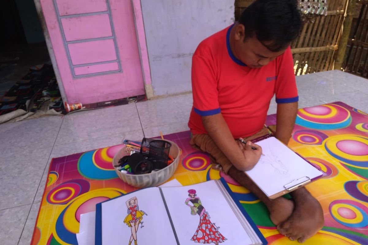 Desainer disabilitas Rahmat Hidayat asal Kabupaten Bandung Barat (KBB) tengah menggambar karyanya. 