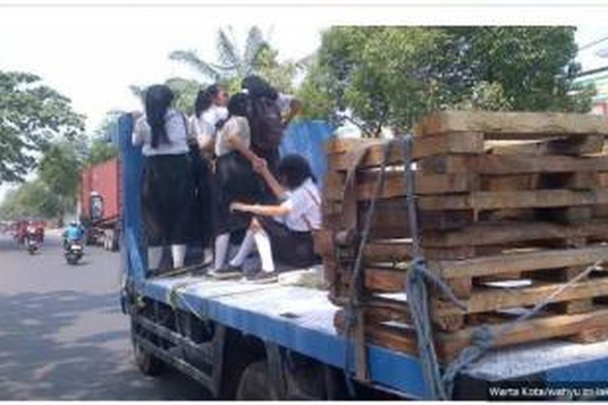 Lima pelajar putri menumpang truk sepulang sekolah, di Jakarta Barat, Kamis (2/10/2014).